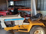 un petit tracteur jaune garé dans un garage