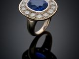 a close up of a ring with a blue sapphire and diamonds