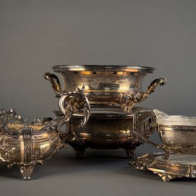 trois plats en argent et un bol en argent posés sur une table