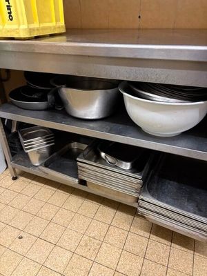 de nombreux bols et casseroles sur l'étagère de la cuisine
