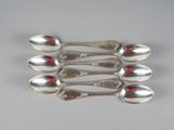six cuillères en argent empilées les unes sur les autres sur une table