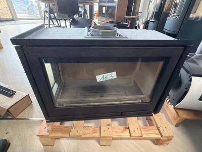 a black stove sitting on a pallet in the middle of a room