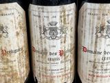 three bottles of red wine are lined up on a table
