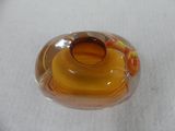 a glass vase with a yellow top on a white surface