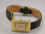 an image of a gold watch with a black leather band