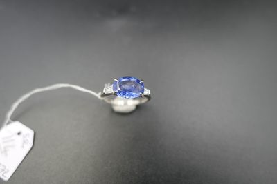 a close up of a ring with a blue sapphire on a table