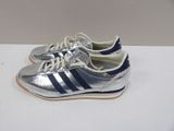 silver and blue adidas sneakers with laces on a white surface