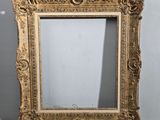 un miroir ancien à cadre doré, orné d'un motif décoratif sur le pourtour