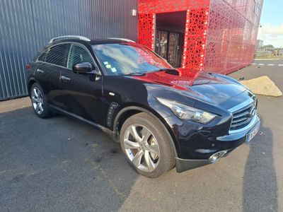 une photo d'un SUV noir garé devant un immeuble