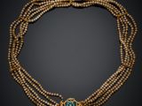 un collier en perles dorées et turquoise, muni d'un fermoir doré