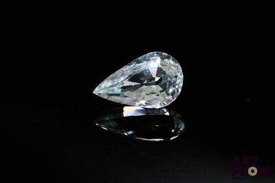 une image représentant un diamant posé sur une surface noire, sur fond noir