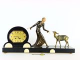 une figurine représentant une femme et un cerf posée sur une table