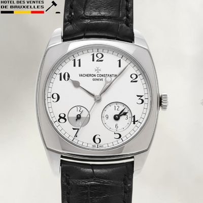 a silver watch with a black leather strap on a white background