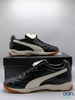 a pair of black and white puma trainers on a box