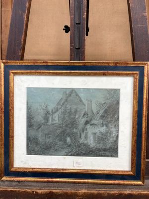 une image représentant une photo d'une maison dans un cadre posé sur un chevalet
