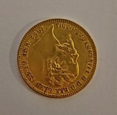 a close up of a gold coin on a white surface