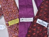 three ties with tags on them are sitting on a table