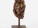 an image of a sculpture of a man ' s head on a wooden base