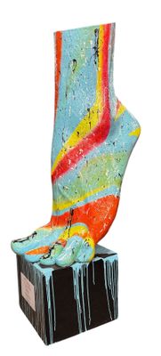 une sculpture représentant une chaussette colorée posée sur un bloc noir