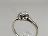 a close up of a diamond ring on a clear surface