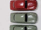 three toy cars are lined up in a row on a white surface