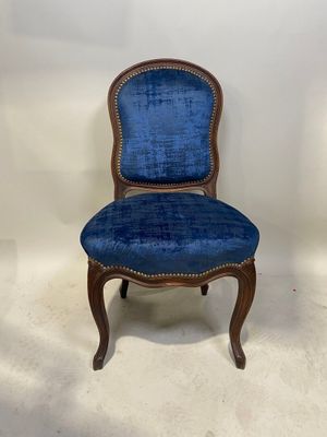 une chaise bleue posée sur un sol blanc, près d'un mur