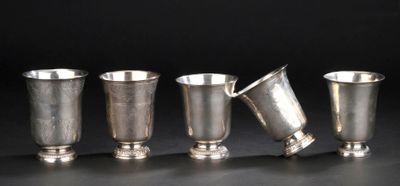 quatre coupes en argent sont alignées sur une surface noire