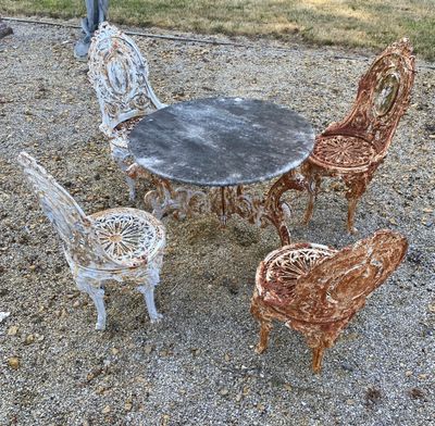 four chairs and a table on the gravel ground