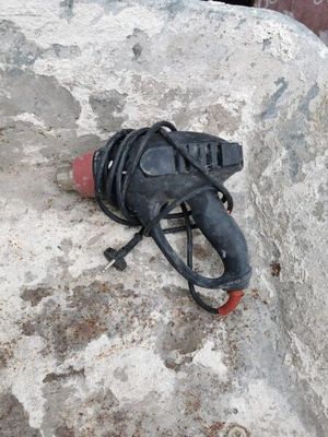 un objet noir posé sur un rocher, muni d'une poignée rouge