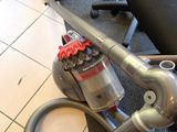 a vacuum that is sitting on the floor next to a chair