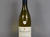 a bottle of white wine sitting on a glass table