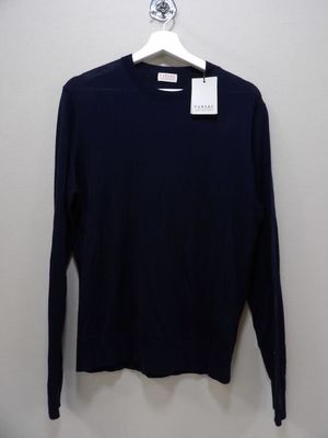 a black sweater hanging on a hanger in front of a white wall