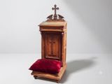 a small wooden chair with a red pillow on it