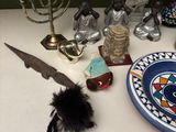 a table with a plate, a bottle opener, a candle, and other items on it