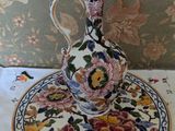 a small vase sitting on a plate on a table