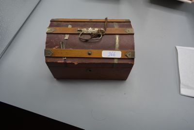 une vieille valise posée sur une table, à côté d'autres objets