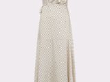 La robe est blanche et est parsemée de pois.