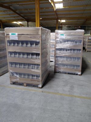 Plusieurs palettes d'eau en bouteille sont empilées dans un entrepôt.