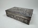 an ornate silver box on a white surface with a white background