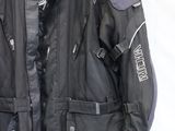 une veste de moto suspendue à un cintre sur un mur blanc dans une pièce