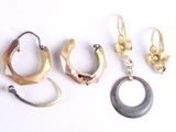three pairs of gold and silver ear rings and a horn shaped earring