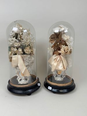 deux cloches en verre contenant des fleurs