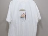 white t - shirt with a picture of a man sitting in a chair under an umbrella on a hanger