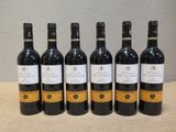 six bouteilles de vin sont alignées sur une table