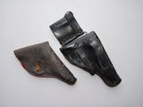two leather holsters on a white surface