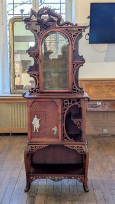 une armoire en bois surmontée d'un miroir, dans une pièce