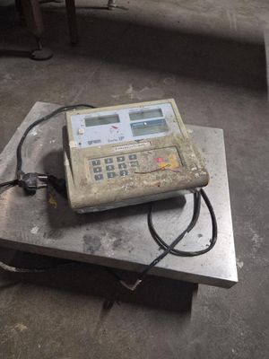 une balance numérique posée sur une table en métal