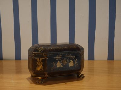 une petite boîte en bois posée sur une table à rayures bleues et blanches