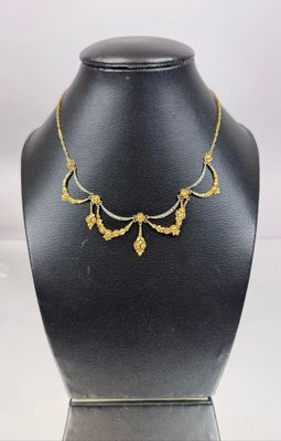 a black mannequin with a gold necklace on top of it