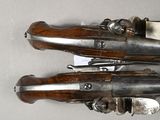 two old guns are sitting on a table with a knife